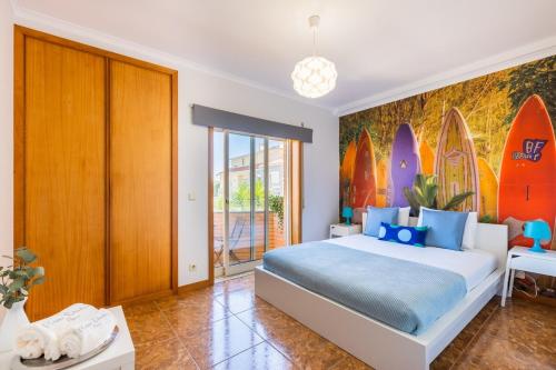 a bedroom with a large bed with surfboards on the wall at Aguda Beach Apartment in Arcozelo
