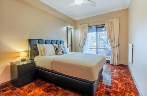 a bedroom with a large bed and a window at Cantinho em Cascais, Spacious 3BR with Balconies in Cascais