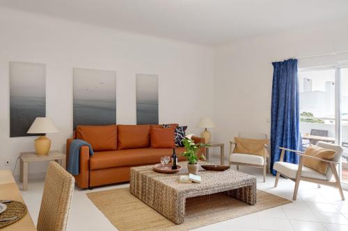a living room with a couch and a table at Prainha Family Fun | Balcony & Pools in Alvor