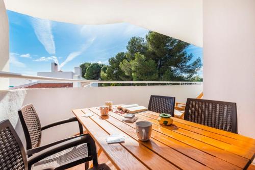 a wooden table and chairs on a balcony at Prainha Family Fun | Balcony & Pools in Alvor