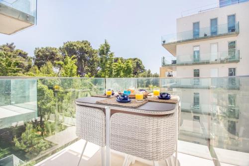 a table on a balcony with a view of a building at Luxury Beach Experience in Lisbon in Oeiras