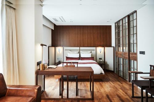 a bedroom with a bed and a wooden table at La Casa Hotel Seoul in Seoul