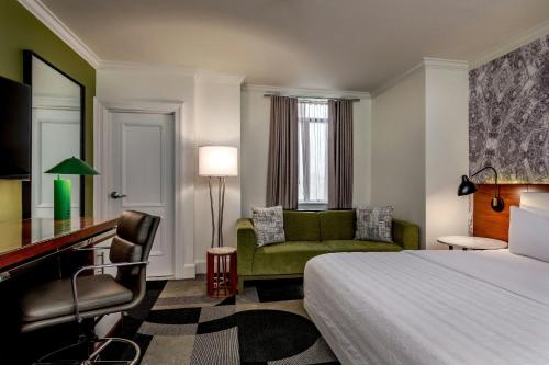 a hotel room with a bed and a desk and a chair at Le Meridien Indianapolis in Indianapolis