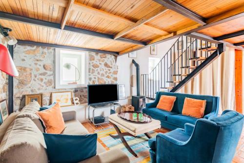 a living room with a couch and a tv at Casalinho de Bicesse in Alcabideche