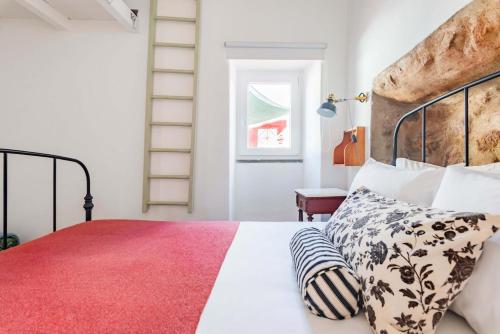a bedroom with a large bed with a red rug at Casalinho de Bicesse in Alcabideche