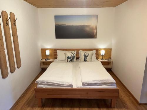 a bedroom with a large bed with two lamps at Apartment with Alpine views in Fügenberg