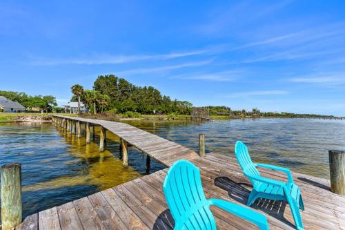two blue chairs sitting on a dock next to the water at 5665 S. Tropical Trail in Merritt Island
