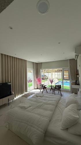 a large white bed in a room with windows at Reef ALjabal Rest in Minthār