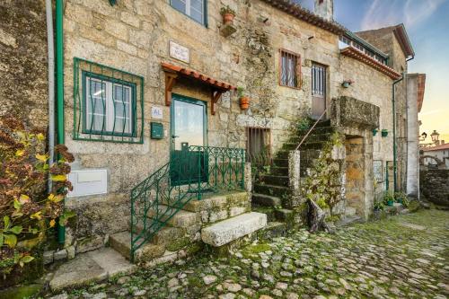 an old stone building with a gate and stairs at Casa Mont'Santo with Balcony & Terrace in Monsanto