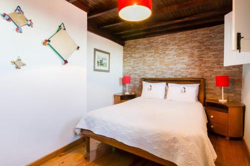 a bedroom with a bed and a brick wall at Casa Mont'Santo with Balcony & Terrace in Monsanto