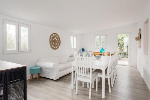 a kitchen and living room with a white table and chairs at Pinhal da Praia em Melides in Quinta da Cascalheirinha