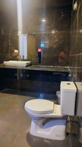 a bathroom with a white toilet and a sink at Orchards Suites Lansdowne in Lansdowne
