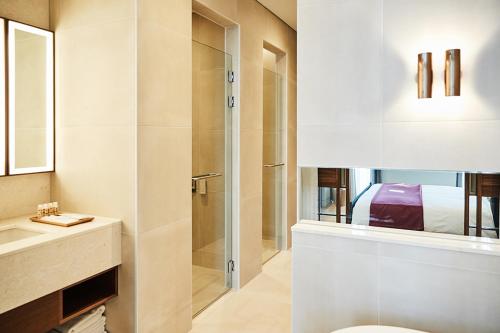 a bathroom with a shower and a toilet and a sink at La Casa Hotel Seoul in Seoul