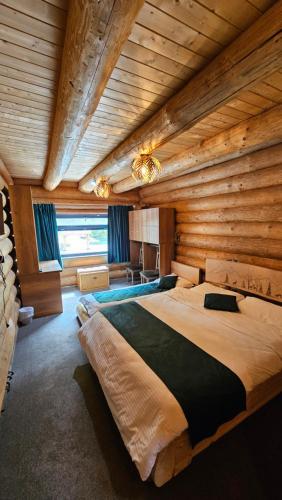 a bedroom with a large bed in a wooden room at Barlogul Ursului in Baia Mare