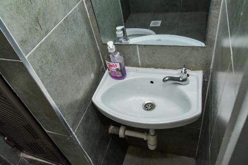 a small bathroom with a sink and a mirror at Royalty homes in Kiambu