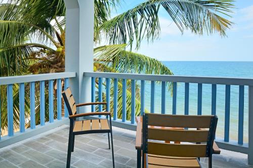 two chairs sitting on a balcony overlooking the ocean at Parrot Cove Lodge in Hopkins