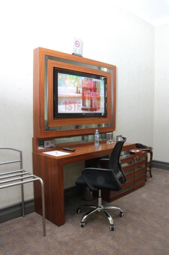 a desk with a chair and a television on top at Batumi World Palace in Batumi