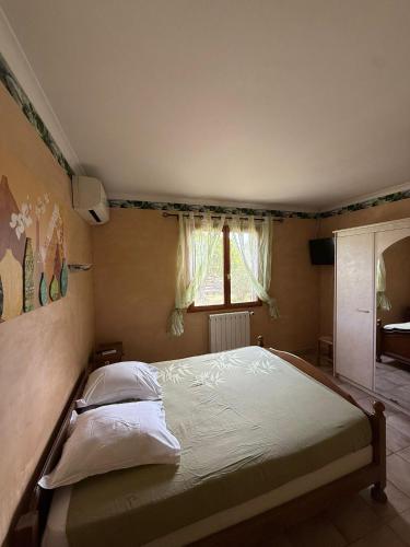 a bedroom with a large bed with a window at Chez Polo Villa avec piscine et pool house privé in Vallon-Pont-dʼArc