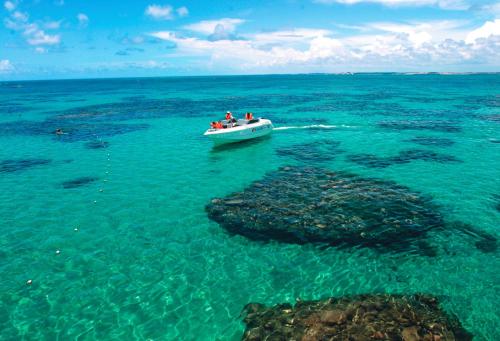a group of people in a boat in the ocean at Hotel Enseada Maracajaú in Maracajaú
