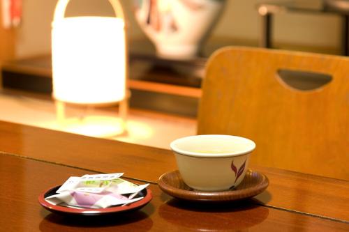 a cup of coffee sitting on a table with a plate at Shugyoku no Yu Yakushido Onsen in Oshu