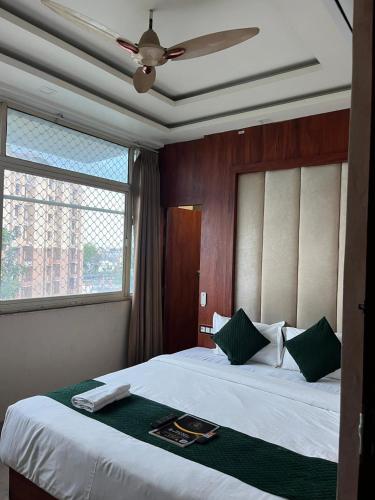 a bedroom with a large bed with a ceiling fan at Hotel V Square in Lucknow