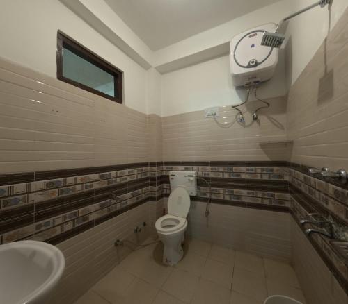 a bathroom with a toilet and a sink at The Pine View in Kasol