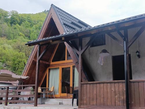 a cabin with a pitched roof and a glass door at Lotru Relax A-Frame in Malaia