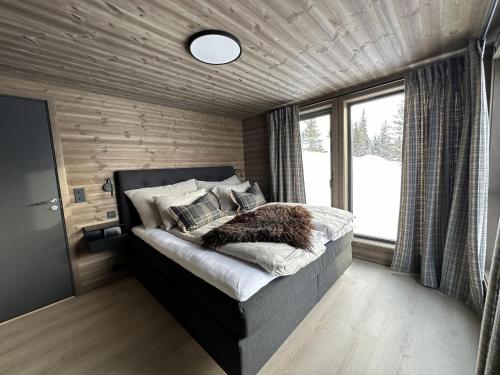 a bedroom with a bed in a room with a window at Hafjell Luxury Lodge in Øyer