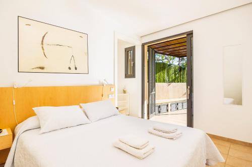 a bedroom with a white bed with towels on it at Alfonsa in Pollença
