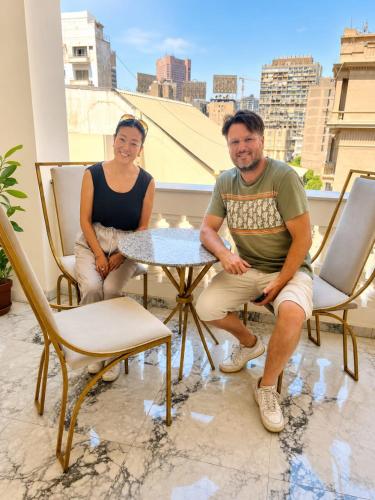 a man and a woman sitting at a table on a balcony at pal ace talaat harb in Cairo