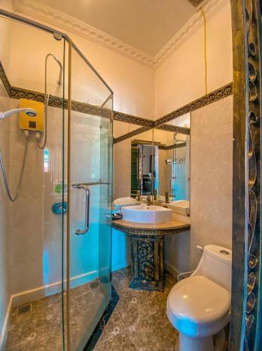 a bathroom with a toilet and a sink and a shower at Le Grand Palais Hotel in Phnom Penh