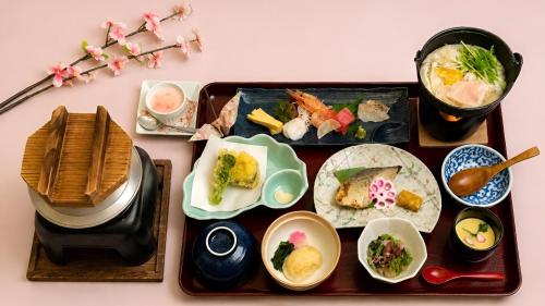 a tray of food on a table with plates of food at 昆布川温泉幽泉閣 in Rankoshi