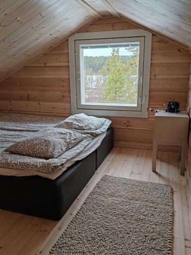 a bedroom with a bed and a window at Villa Goškanjávri in Inari