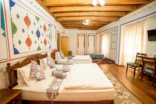 a bedroom with three beds in a room with wooden ceilings at As-Salam Boutique Hotel in Bukhara