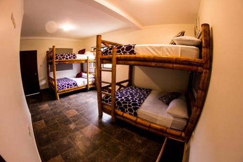 a room with three bunk beds in a room at Paradise Project Hostal in Montañita