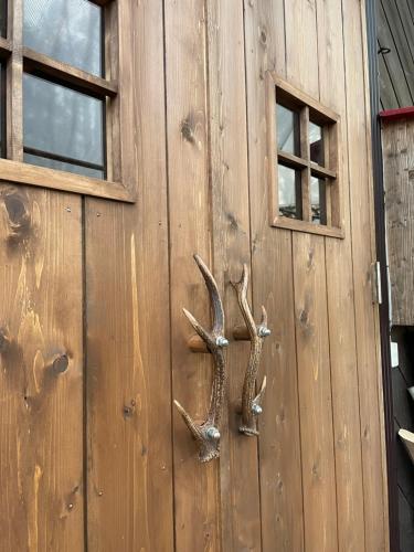 a wooden door with antlers on it with two windows at Camping field Kisokodo in Kiso-Fukushima