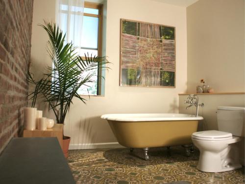 a bathroom with a tub and a toilet and a plant at Casa Hudson in Haverstraw