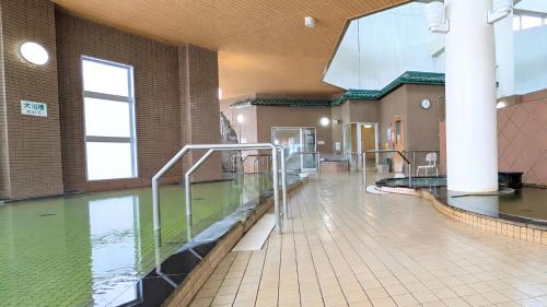 a large pool of water in a building with a pool at 昆布川温泉幽泉閣 in Rankoshi