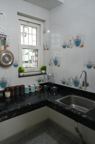 a kitchen counter with a sink and a window at Retreat Homes in Siliguri