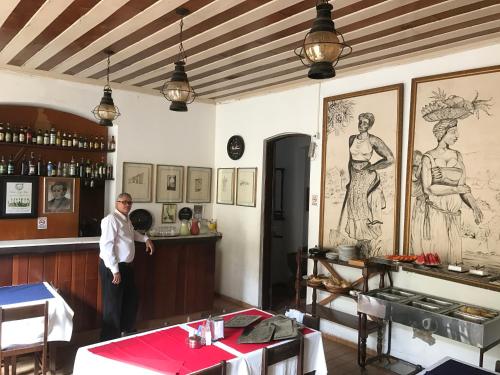 a man standing in a room with a bar at Pousada Colonial Penedo - Alagoas in Penedo