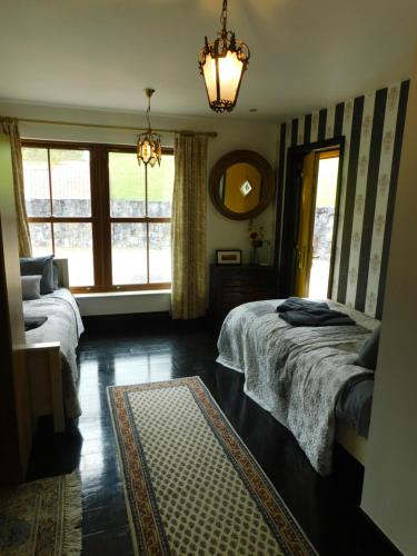 a bedroom with two beds and a large window at Willow Cottage Accommodation F91X0C8 in Sligo
