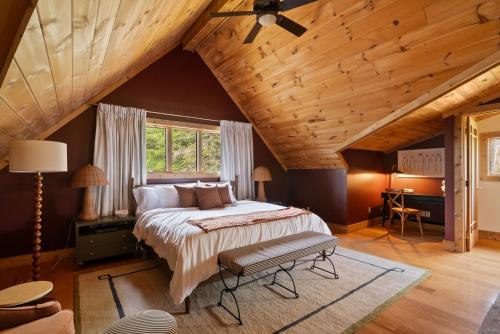 a bedroom with a large bed and a wooden ceiling at Velvet Timber Haus | HotTub, Sauna, Firepit, Games in Windham