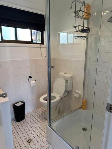 a bathroom with a toilet and a glass shower at Tranquil Waters Edge Escape in Sanctuary Point