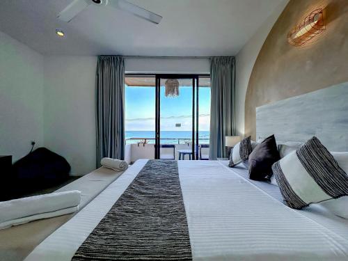 a bedroom with a large bed with a view of the ocean at Linará in Hikkaduwa