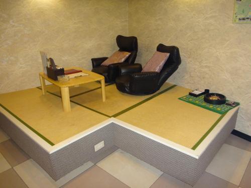 a living room with two chairs and a table at Utility Hotel Coo in Yokoshibahikari