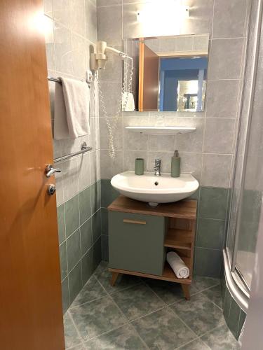a bathroom with a sink and a shower at Hotel Weldi in Győr