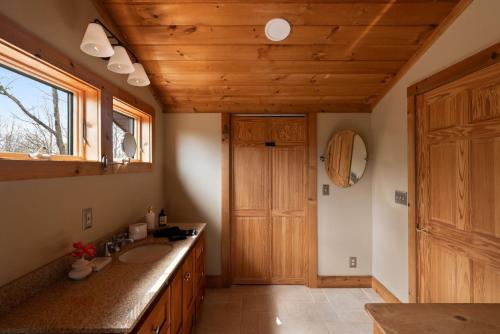 a bathroom with a sink and a wooden ceiling at Velvet Timber Haus | HotTub, Sauna, Firepit, Games in Windham
