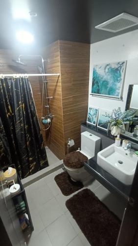 a bathroom with a sink and a toilet and a shower at Suite City view in Manila