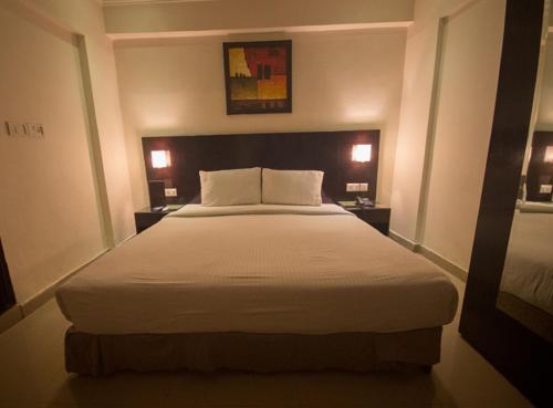 a bedroom with a large bed with white sheets at ANR Hotels in Lucknow