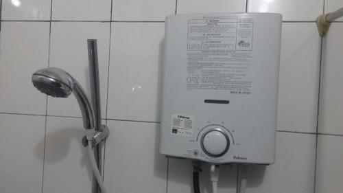 a water dispenser on the wall of a bathroom at Homestay Triniti in Lembang